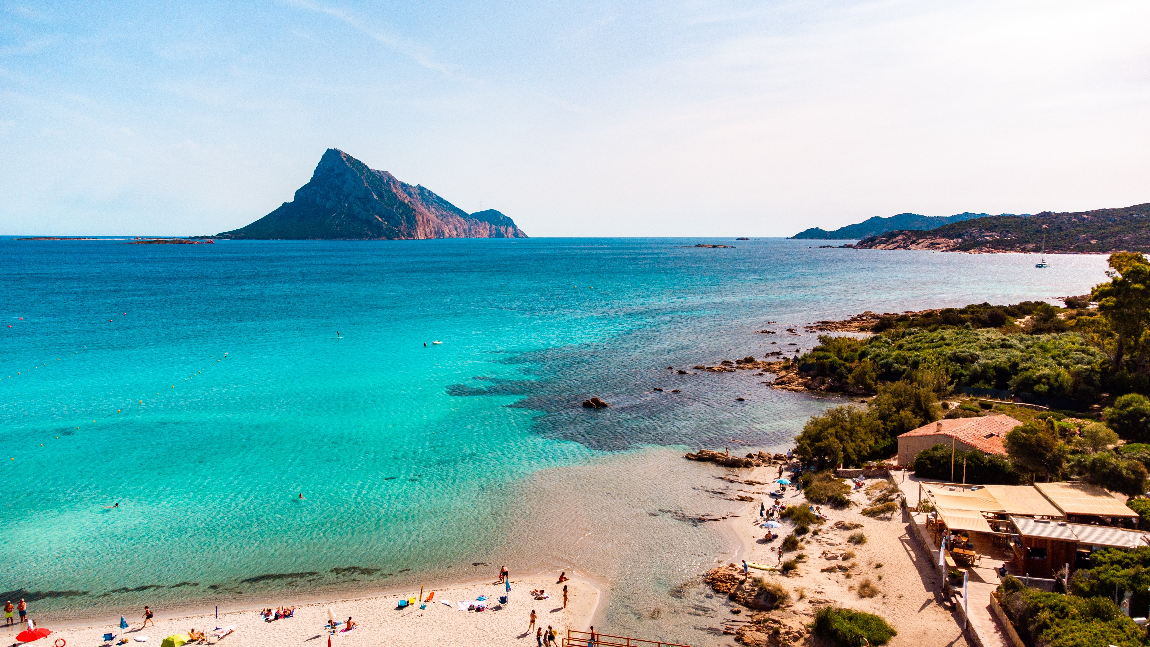 Strand mit türkisem Wasser und Bergpanorama